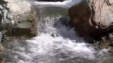 Güçlü şelale doğal ortamda kayaların üzerinde çağlıyor.