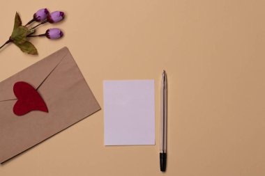 Dünya iltifat günü. Rose, kraft kâğıdı zarf ve yukarıdan çekilen boş kartlar için sanatsal maketler. Düz yatay minimalist bileşim.
