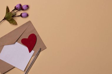 Dünya iltifat günü. Sevgililer Günü. Kalp, kraft kâğıdı zarf ve yukarıdan atılan boş kartlar için sanatsal maketler. Düz yatay minimalist bileşim.