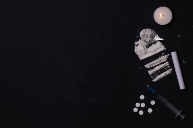 Siyah arka plan. Yuvarlanmış banknotlu kokain tozu, şırınga, mum, uyuşturuculu kaşık. Uyuşturucu ve Yasadışı Uyuşturucu Kaçakçılığına Karşı Uluslararası Gün kavramı. Yüksek kalite fotoğraf