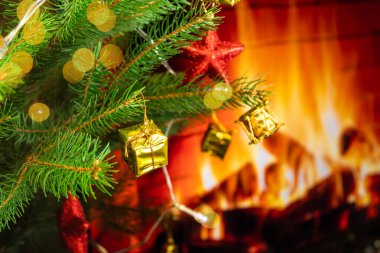 Ateşli bir şöminenin arka planında Noel ağacı