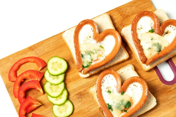Sosiste çırpılmış yumurta, kalp şeklinde sosis, kalp, kahvaltı, tahtada üst manzara.