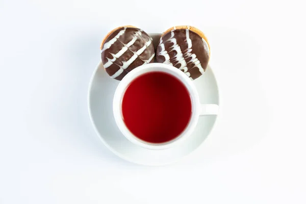 Bir fincan çay, meyve çayı, beyaz arka planda makarna, çikolatalı kurabiye, zencefilli çörek, üst manzara, izole edilmiş