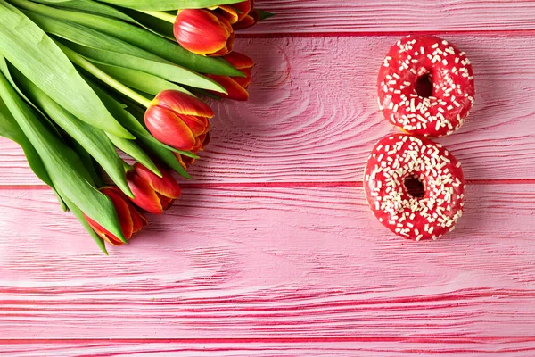 8 Mart, kadınlar günü, pembe arka planda pembe çörekler, üst manzara, laleli buket.