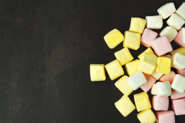 Marshmallow, koyu bir arka planda, dağınık, farklı renkler, zengin sarı, üst görünüm, dokulu arka plan