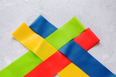 Birbirlerine bağlı fitness döngüleri, yakın çekim üst görüntüde elastik bantlar, taştan bir arka plan.