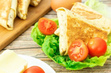 Yakından yeşil bir yaprağın üzerinde üçgen bir shawarma kızartması.