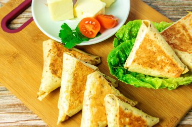 Tahtada kızartılmış üçgenler, altın kabuklu, yakın planda teke tek.