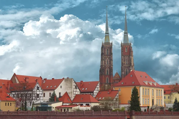 Eski yılların renkli tuğlalı evleri, saatli Wroclaw şehri yüksek kilisesi.
