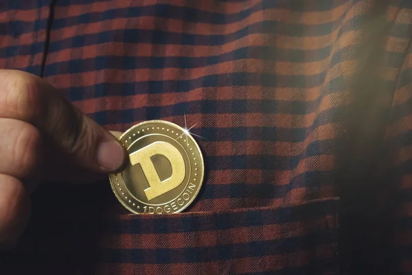 Adamın eli cebine bir Dogecoin sikkesi koyuyor, bir kripto para devi.