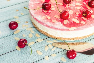 Ev yapımı kek, yakın plan kirazlı cheesecake, hafif arka planda çikolata taneli kirazlar.