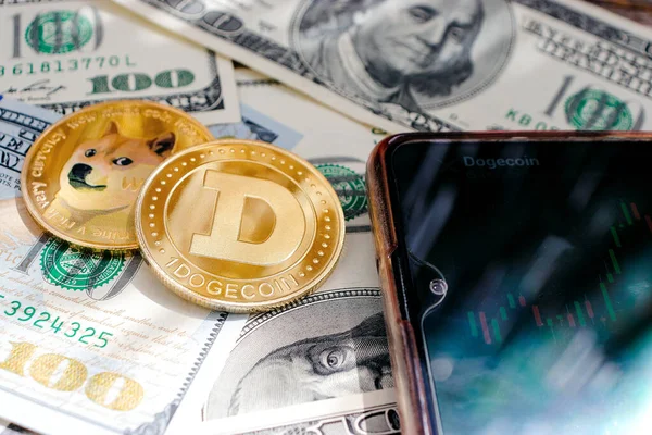 Dolar banknotlarının arka planında Dogecoin, grafikli telefon, güneş ışınları