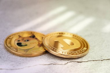 Dogecoins on a light background under the rays of the sun in close-up, gold coins, cryptocurrency clipart