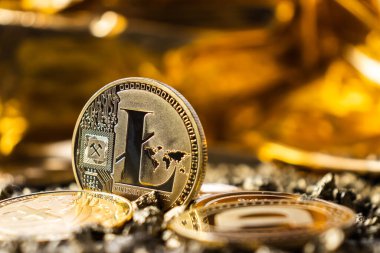 Litecoin cryptocurrency close-up on yellow and gold background, back side of coin, mining logo