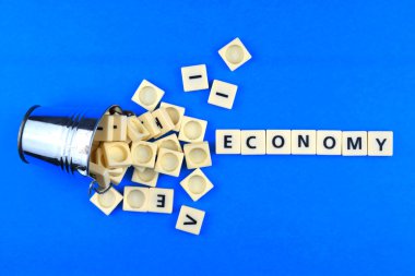 Mavi arkaplan üzerine dağınık kelimelerle ekonomi ifadeleri. İş ve ekonomi kavramı. Seçici odak resim.