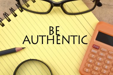 Selective focus image of calculator,pencil,magnifying glass and spectacles with BE AUTHENTIC wording