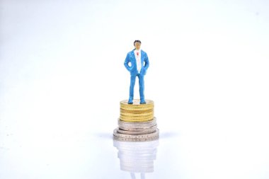 Madeni paranın üzerinde duran minyatür zengin insanların seçici odak noktası. İş ve ekonomi kavramı