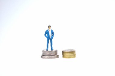 Madeni paranın üzerinde duran minyatür zengin insanların seçici odak noktası. İş ve ekonomi kavramı