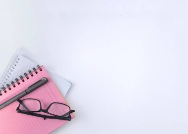 Gözlüklerin seçici odak görüntüsü ve kopya alanı olan beyaz bir arkaplan üzerine not defteri. Kavramsal fotoğraf