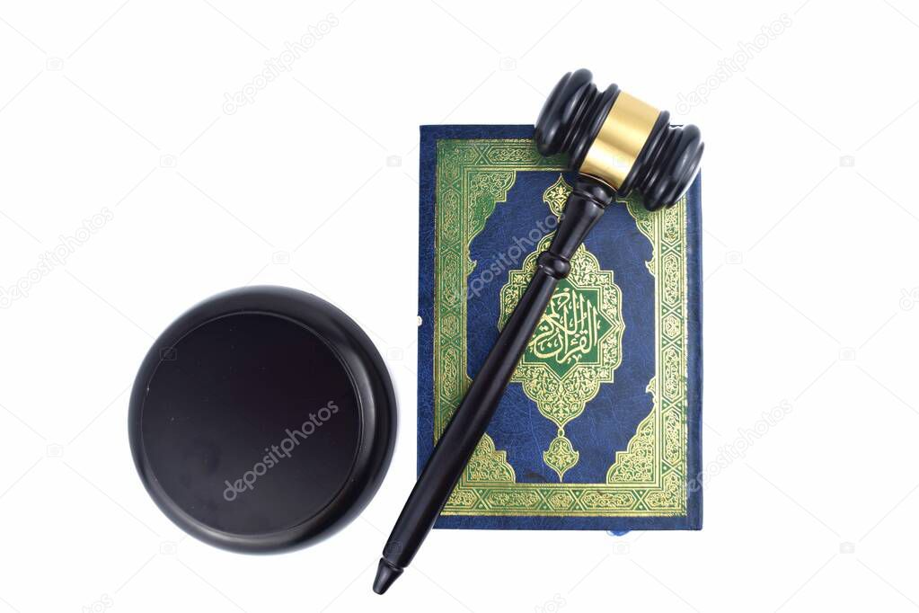 An image of Quran or holy book of Muslim people with gavel isolated in white background. Shariaa law concept