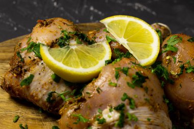 Çiğ tavuk bacağı, limon ve bitkilerle..