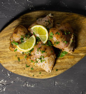 Çiğ tavuk bacağı, limon ve bitkilerle..