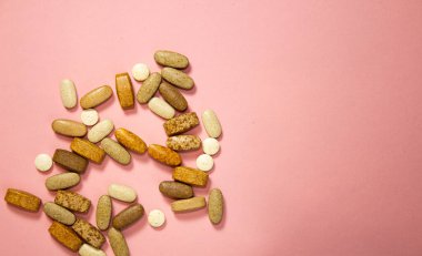 Pembe arka planda beyaz kapsül haplarının düz yerleşimi