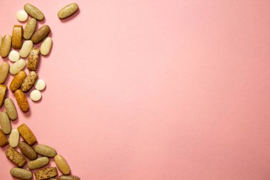 Pembe arka planda beyaz kapsül haplarının düz yerleşimi