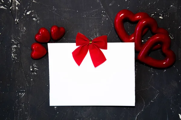 Congratulazioni per San Valentino. Rosa rossa e biglietto di auguri con segno di cuore su sfondo nero vista dall'alto copia spazio. Stile. — Foto Stock