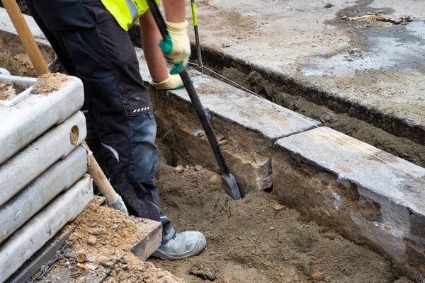 Worker replace kerbstones street network. Close up