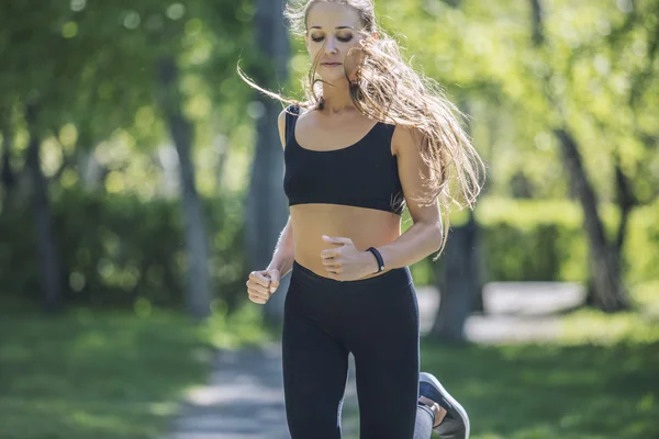 Beautiful young woman in sportswear Jogging in the Park with