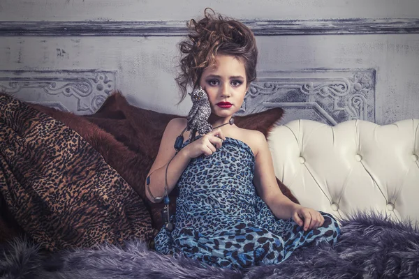 Little baby girl in the image of a glamorous model in a luxuriou