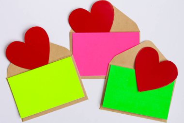 İçlerinde kırmızı kalpler olan parlak renkli zarflar.