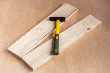 Bir çekiç ve ahşap arka planda iki tahta.