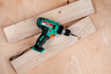 Ahşap arka planda iki tahta üzerinde siyah ve yeşil cıvata kesici.