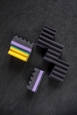 dark violet and black sponges and a yellow sponge on black background