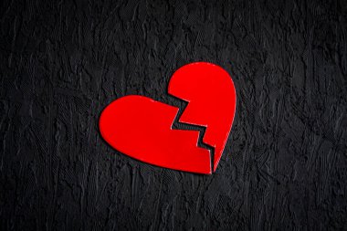 a broken red heart on black background