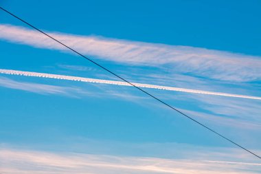 blue evening sky with pink strokes and a wire line
