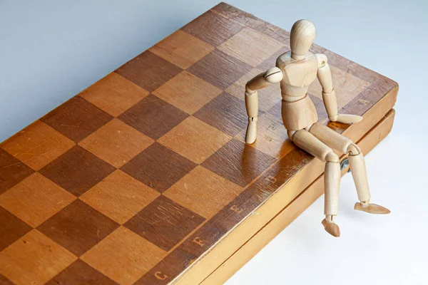 Wooden Mannequin Sitting Chess Board White Background — Stock Photo, Image