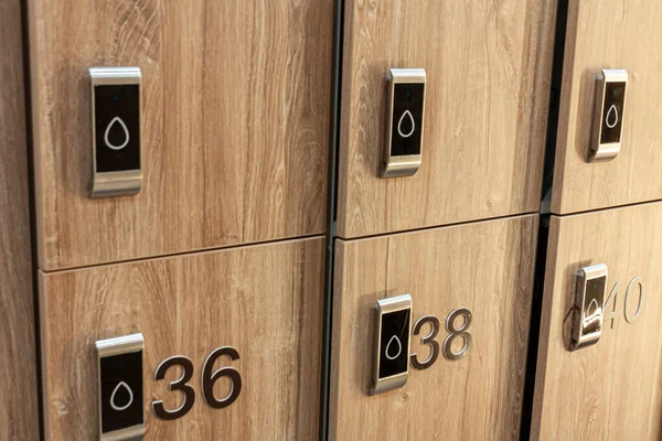 light brown lockers with black numbers in a locker room