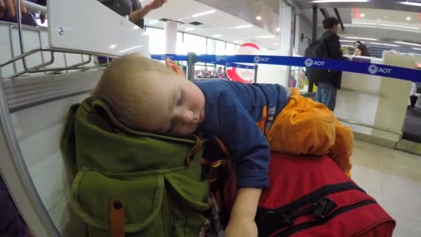 กรุงเทพฯ ประเทศไทย 22 มกราคม ค.ศ. 2016: เด็กชายนอนบนกระเป๋าเดินทางในสนามบิน — วีดีโอสต็อก
