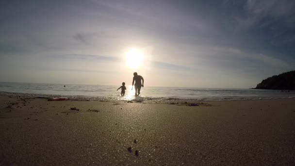 Mann und Junge laufen aus dem Meer — Stockvideo