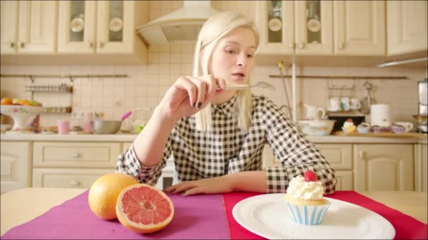 Blond kvinna att välja mellan frukt och bakverk — Stockvideo