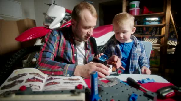 Padre e Hijo Montando el Coche de Juguete de Partes — Vídeo de stock