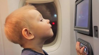 Çocuk çizgi uçak koltuk ekranda izlerken