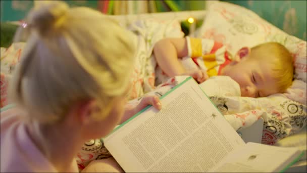 Moeder lezen voor het slapen gaan boek aan haar zoon — Stockvideo