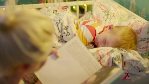 Mamma läser läggdags bok till sin son — Stockvideo