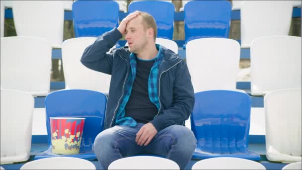 Upset guy sitting on the tribune — Stock Video