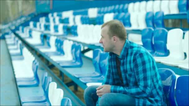 Joven saliendo del estadio tribuna — Vídeos de Stock