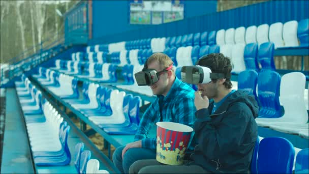 Amigos en gafas VR enraizándose activos en el estadio tribuna — Vídeos de Stock